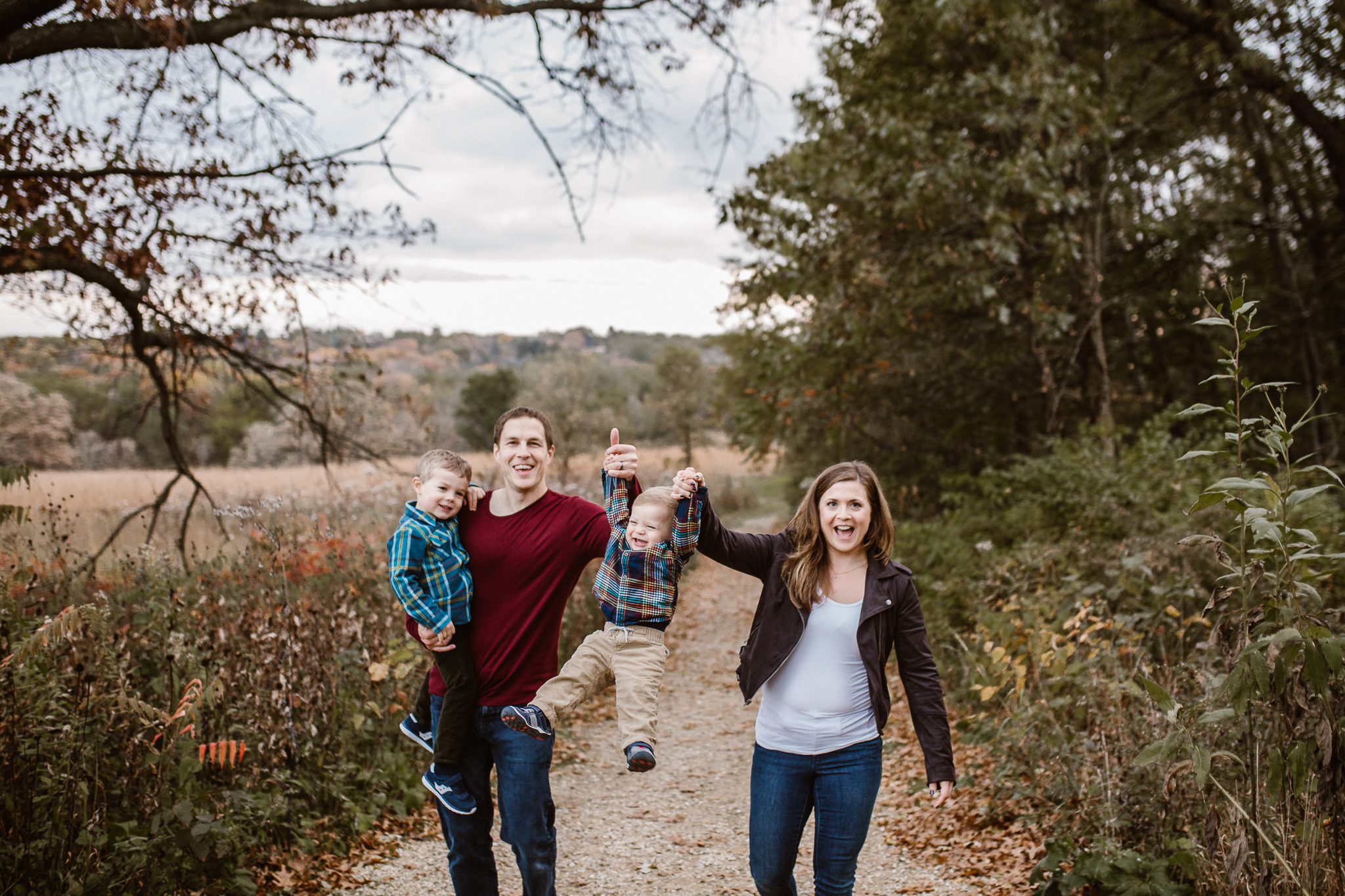 Family of four holding hands and swinging their boy up.