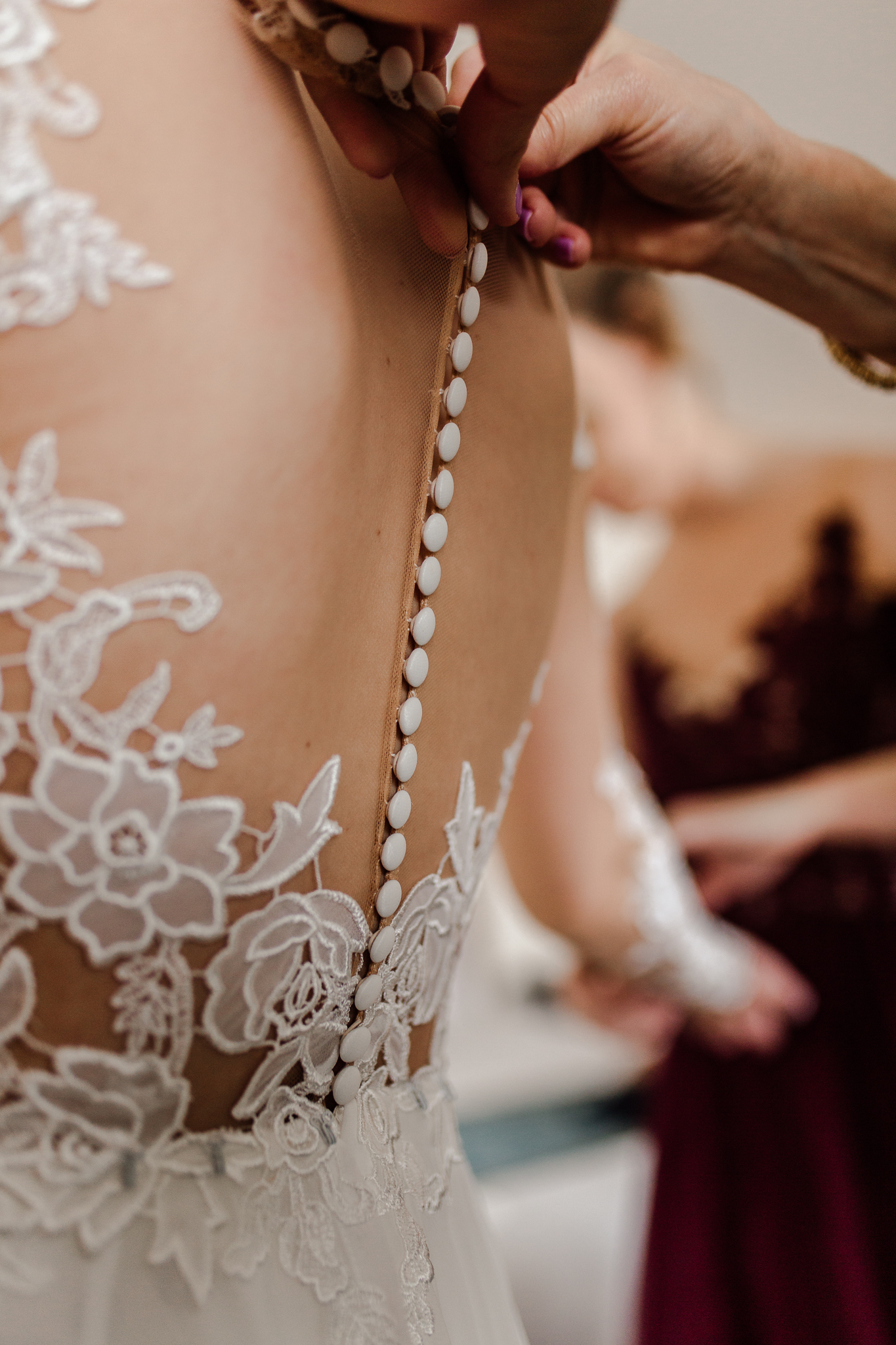 Mother of the bride buttoning up her dress.