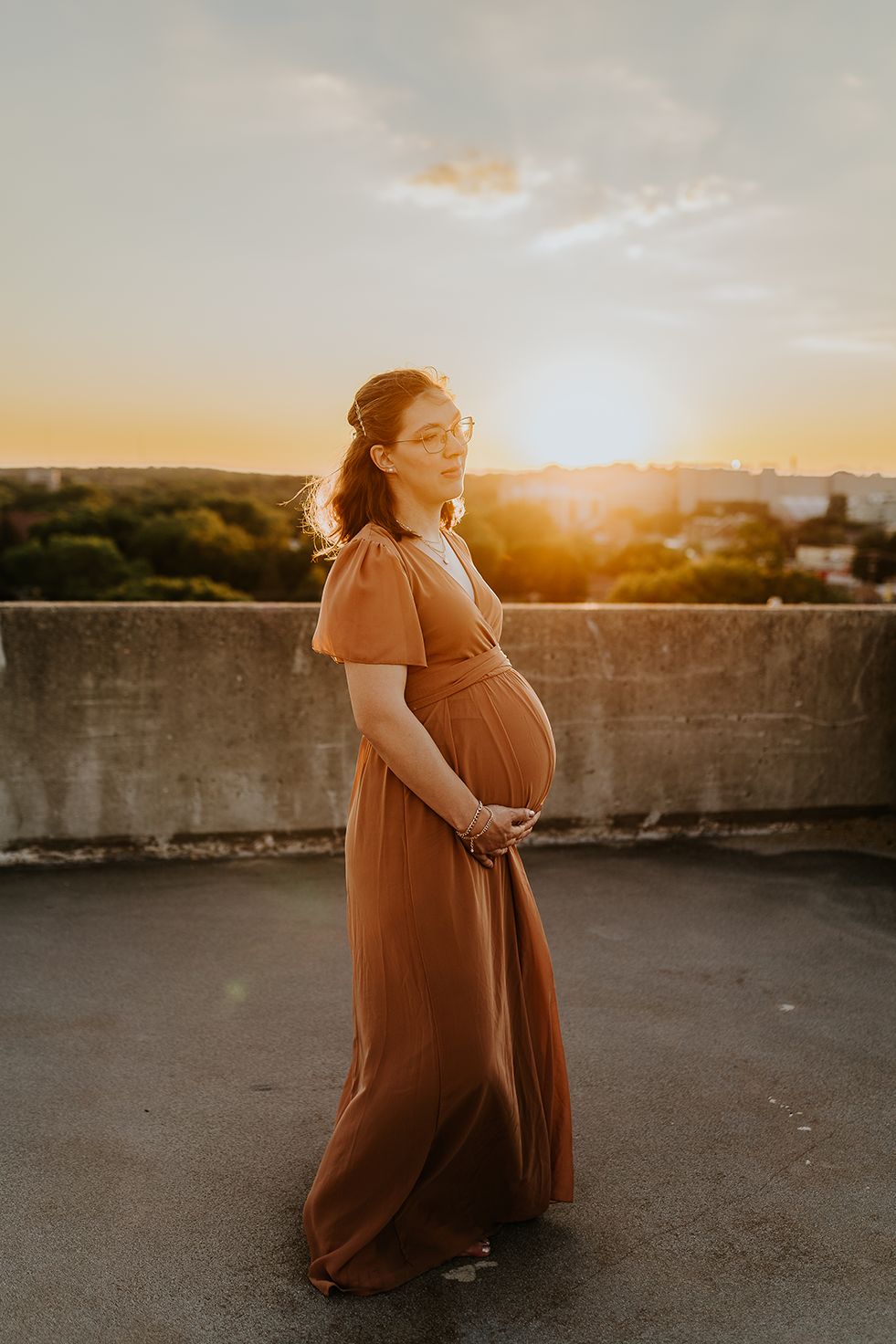 Pregnant mother bathed in golden sunset light on a Madison rooftop.