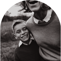 Boy and his mom laughing hard outside.